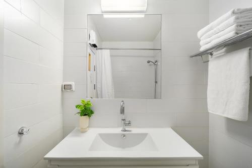 a white bathroom with a sink and a mirror at Keshet Eilon Galilee Views Retreat by Sea N' Rent in Elon