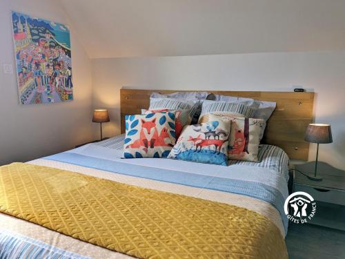 a bedroom with a bed with pillows on it at Le Pêcheur d'étoiles in Origné