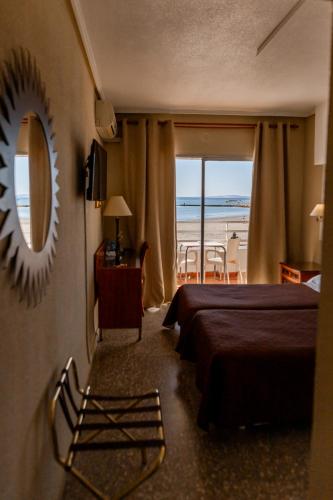 a hotel room with a bed and a view of the beach at Hotel Polamar in Santa Pola