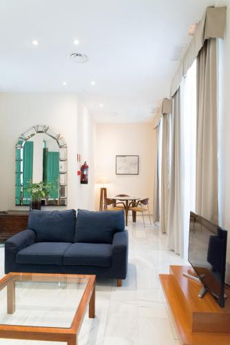 a living room with a blue couch and a table at Hotel Inglaterra in Granada