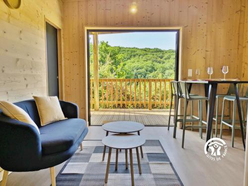 a living room with a couch and a table at Chalet 23 Le Moulin, Camping de Coupeau, 4 personnes in Saint-Berthevin