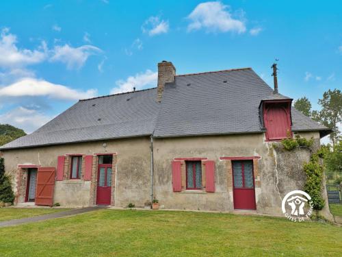 an old house with red shutters on a yard at Gîte du Hérisson, 6 personnes 