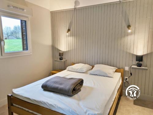 Un dormitorio con una cama con una almohada encima. en Chalet la Brême, en Villiers-Charlemagne