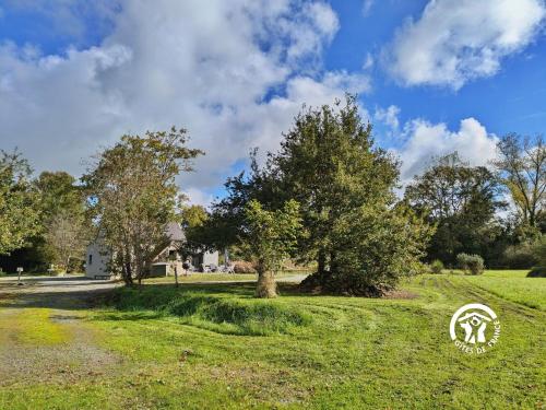 un champ verdoyant avec des arbres et une maison dans l'établissement La Lande du Pont, à Hambers