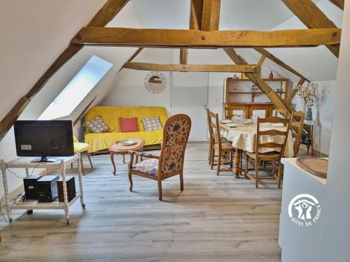 ein Wohnzimmer mit einem gelben Sofa und einem Tisch in der Unterkunft La Janvrie, 5 personnes in La Rouaudière