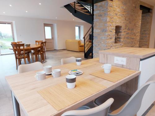 a dining room with a wooden table and chairs at Un air de campagne in Saint-Pierre-la-Cour