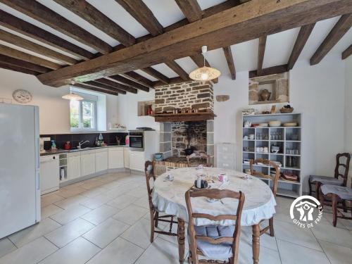 een keuken met een tafel en stoelen in een kamer bij Les gallinettes in Neuilly-le-Vendin