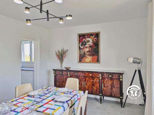 a dining room with a table and a painting on the wall at La maison de Sainte Suzanne, 5 pers in Sainte-Suzanne