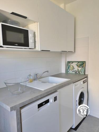a kitchen with a sink and a washing machine at La maison de Sainte Suzanne, 5 pers in Sainte-Suzanne