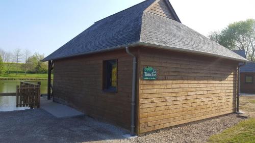 a small wooden building with a sign on it at Chalet la Tanche in Villiers-Charlemagne