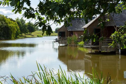 a river with a house and a building on it at Chalet la Tanche in Villiers-Charlemagne