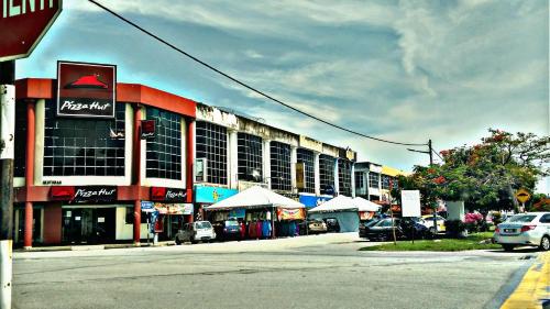 a street with cars parked in front of a building at Grand Kapar Hotel Kuala Selangor in Kuala Selangor