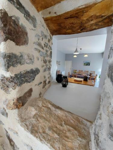 a room with a stone wall and a living room at Le Moulin de Gratte Sac in Voutré