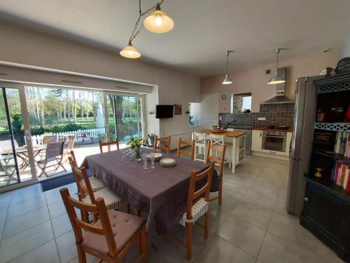 a kitchen and dining room with a table and chairs at Le Moulin de Gratte Sac in Voutré