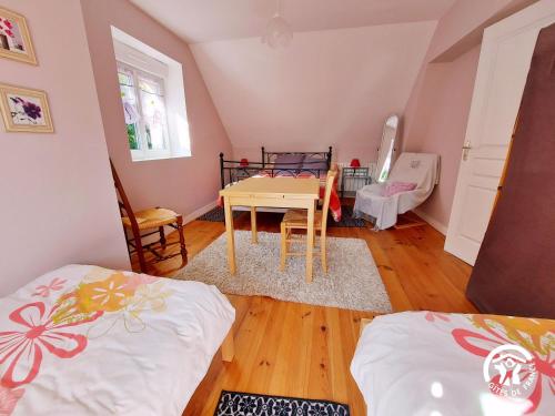 a room with two beds and a table and chairs at La Semondière in Saint-Thomas-de-Courceriers