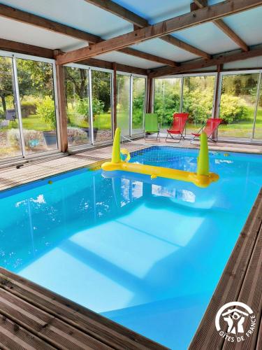 a swimming pool with an inflatable pool toy in a house at La Semondière in Saint-Thomas-de-Courceriers