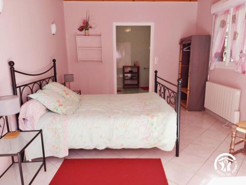 a bedroom with a bed and a red rug at La Semondière in Saint-Thomas-de-Courceriers