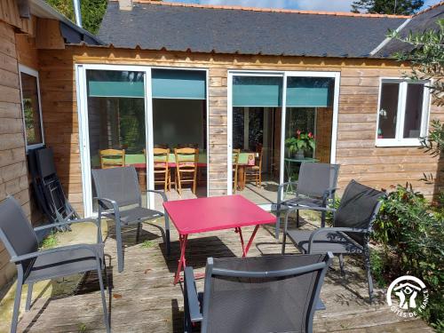 a patio with a red table and chairs at La Semondière in Saint-Thomas-de-Courceriers