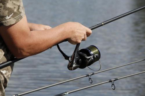 a man holding a fishing rod in his hand at Chalet l'Anguillle in Villiers-Charlemagne