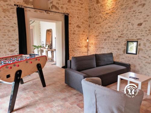 a living room with a couch and a pool table at Gîte Les Haies de Tresmes, jusqu'à 6 personnes in Gesvres
