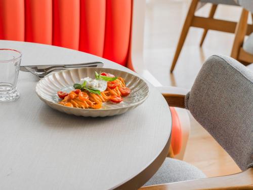 a bowl of food sitting on a table at Falkensteiner Residences Jesolo in Lido di Jesolo