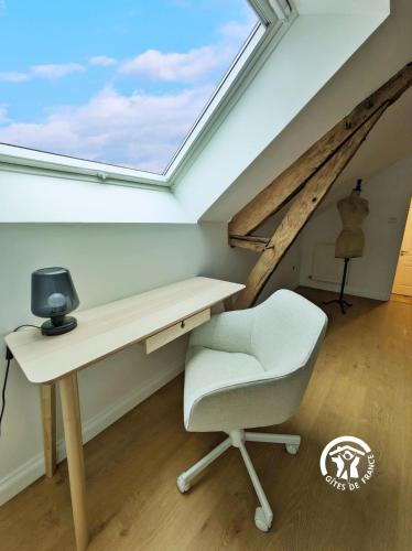 a desk and a chair in a room with a window at Gîte Les Haies de Tresmes, jusqu'à 6 personnes in Gesvres