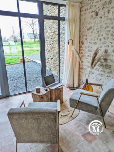 a living room with a couch and a laptop on a table at Gîte Les Haies de Tresmes, jusqu'à 6 personnes in Gesvres