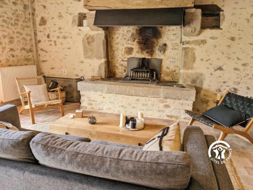 a living room with a couch and a fireplace at Gîte Les Haies de Tresmes, jusqu'à 6 personnes in Gesvres