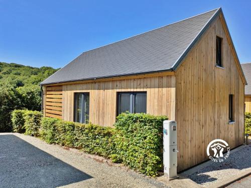 a wooden building with a roof on a street at Chalet 24 La Forêt, Camping de Coupeau, 4 personnes in Saint-Berthevin