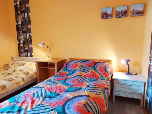 a bedroom with a bed and a nightstand and a bed and a table at La Boulaie in Saint-Ouen-des-Toits