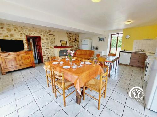 a kitchen and dining room with a table and chairs at La Boulaie in Saint-Ouen-des-Toits