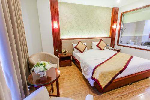 a hotel room with a bed and a chair at Tu Son Luxury Hotel in Bắc Ninh