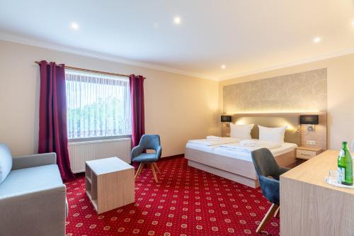 a hotel room with a bed and a table and chairs at Hotel am Gothensee in Heringsdorf