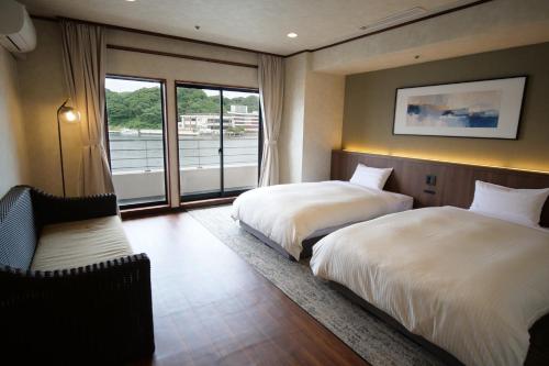 a hotel room with two beds and a window at TAOYA Nachikatsuura in Nachikatsuura