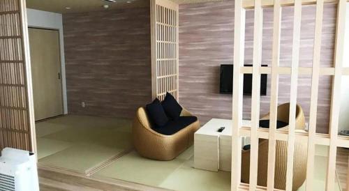 a living room with a chair and a table at Centrale Hotel Kyotango in Kyotango