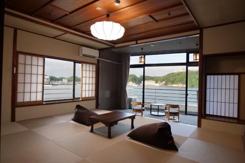 a living room with a table and some windows at TAOYA Nachikatsuura in Nachikatsuura