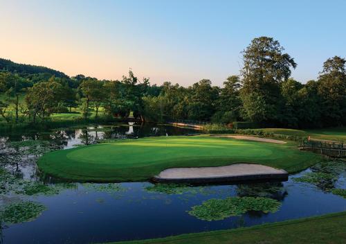 an aerial view of a golf course with a pond at Vale Resort in Hensol