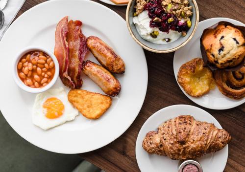 a table with plates of breakfast food on it at Vale Resort in Hensol