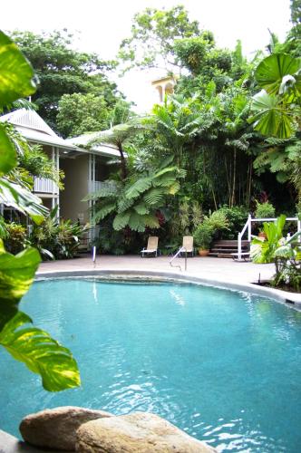 a swimming pool in front of a house at Palm Cove Tropic Apartments in Palm Cove