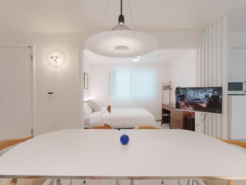 Una habitación blanca con una cama y un televisor. en Kefi, en Seúl