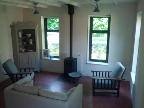 a living room with a couch and two windows at Vakantie appartement in dorpskern in Diever