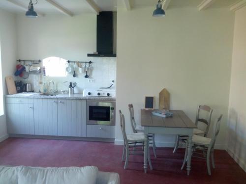 uma cozinha com mesa e cadeiras num quarto em Vakantie appartement in dorpskern em Diever