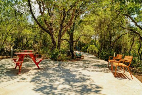 a red table and chairs on a path in a park at Keshet Eilon Galilee Views Retreat by Sea N' Rent in Elon