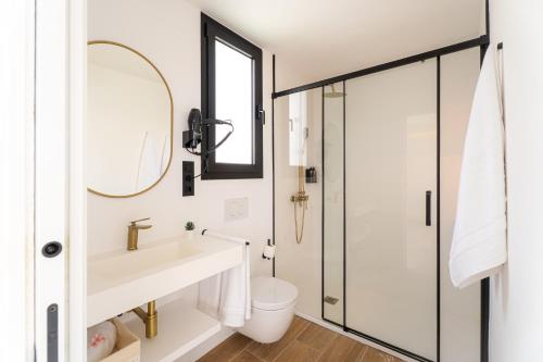 a bathroom with a sink and a toilet and a mirror at Apartamento moderno con jacuzzi y vista mar in Cotillo