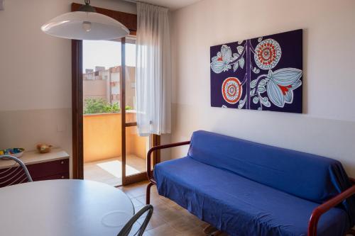 a living room with a blue couch and a table at Aurora Residence in Lido Adriano