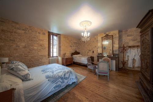 a bedroom with a bed and a table and chairs at Les Petits Cousins Du Québec - Chambres D’hôtes à Domme in Domme