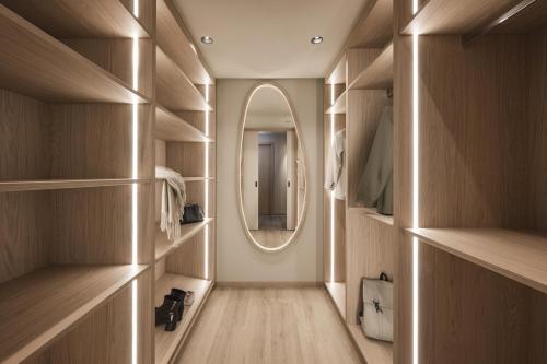 a dressing room with wooden cabinets and a mirror at Falkensteiner Family Resort Lido Superior in Chienes