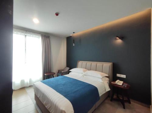 a bedroom with a large bed and a black wall at In Trend Hotel in Cukai