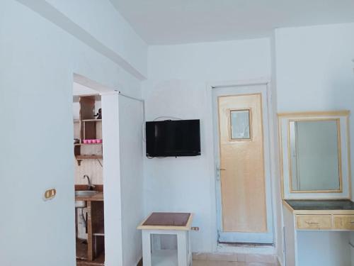 エル・アラメインにある2B equipped basement chalet with 2 beds pool view green beach villa 114bの白い壁のリビングルーム(テレビ付)