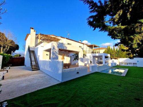 een wit huis met een gazon ervoor bij Apartaments Gorgot in Empuriabrava